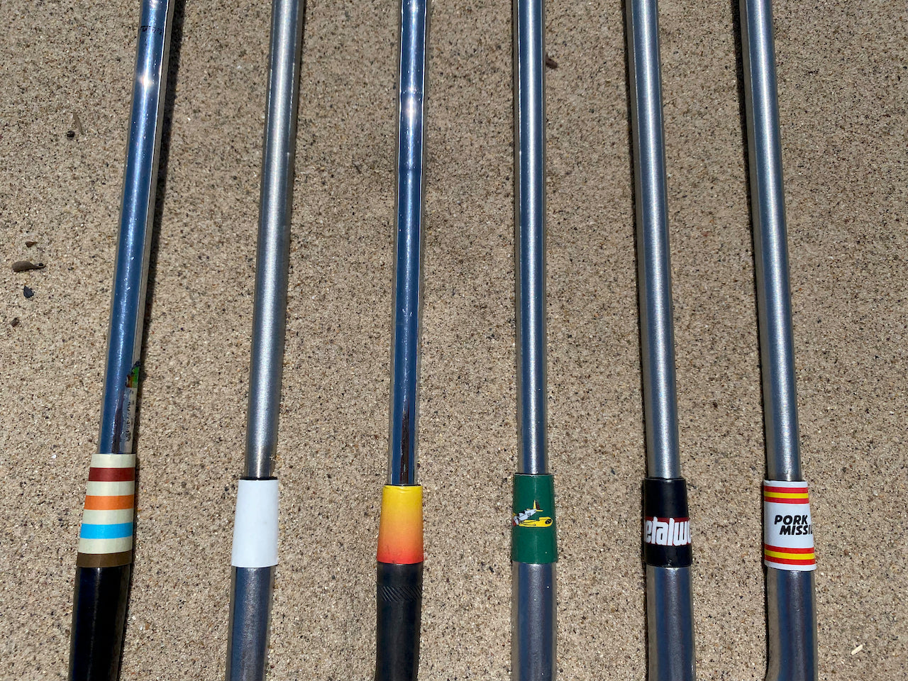 An array of custom ferrule wraps on golf clubs including penmar social club, metalwood, pork missile, and more designs.